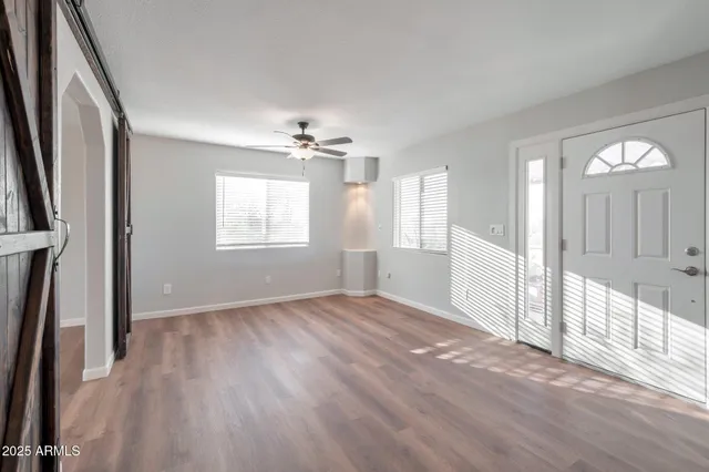 an empty room with wooden floor and a window