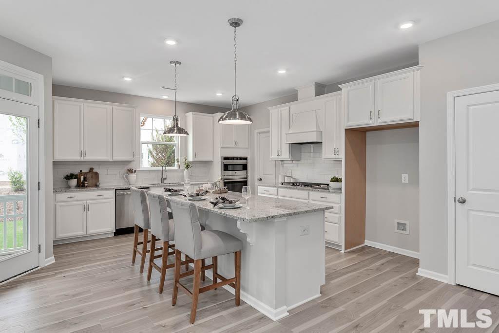 112 Thrower Lane Garner, NC 27529 - Photo 12 of 38 a kitchen with a sink a center island stainless steel appliances and cabinets