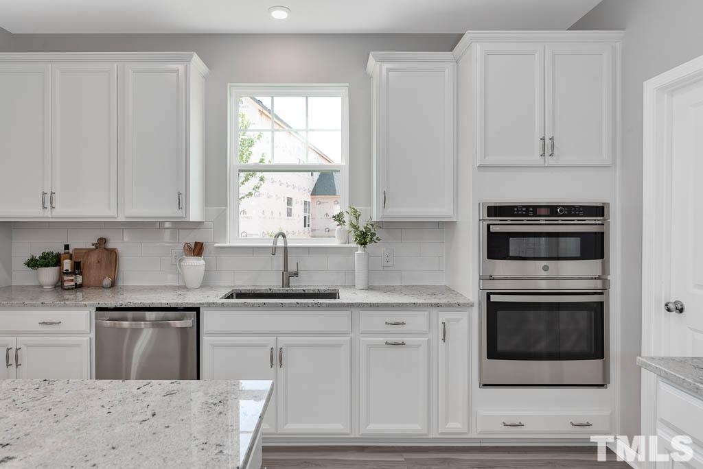 112 Thrower Lane Garner, NC 27529 - Photo 13 of 38 a kitchen with granite countertop white cabinets and white appliances