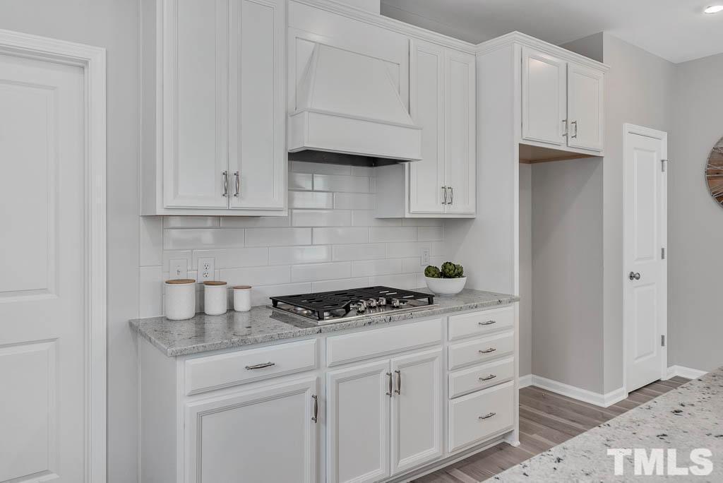 112 Thrower Lane Garner, NC 27529 - Photo 14 of 38 a kitchen with white cabinets and a stove with a sink