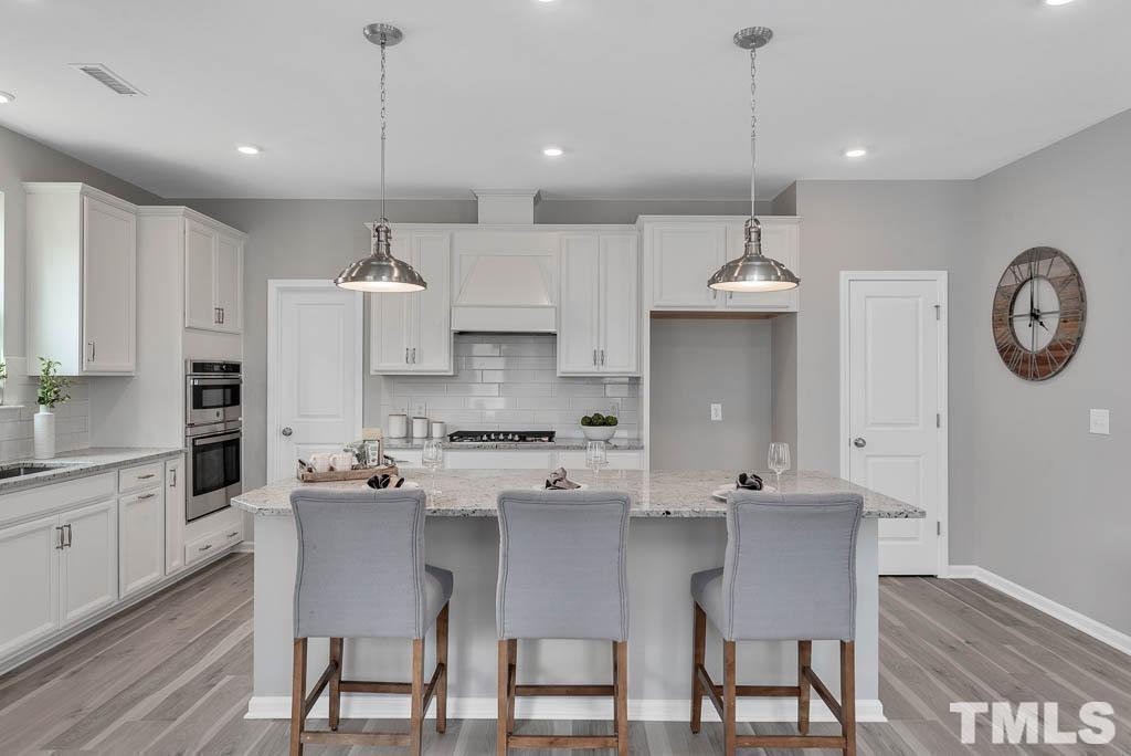 112 Thrower Lane Garner, NC 27529 - Photo 16 of 38 a kitchen with a dining table chairs sink and cabinets