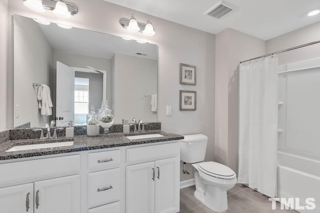 112 Thrower Lane Garner, NC 27529 - Photo 29 of 38 a bathroom with double vanity sink a mirror and a toilet