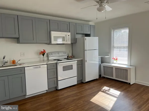 a kitchen with a sink a refrigerator and cabinets