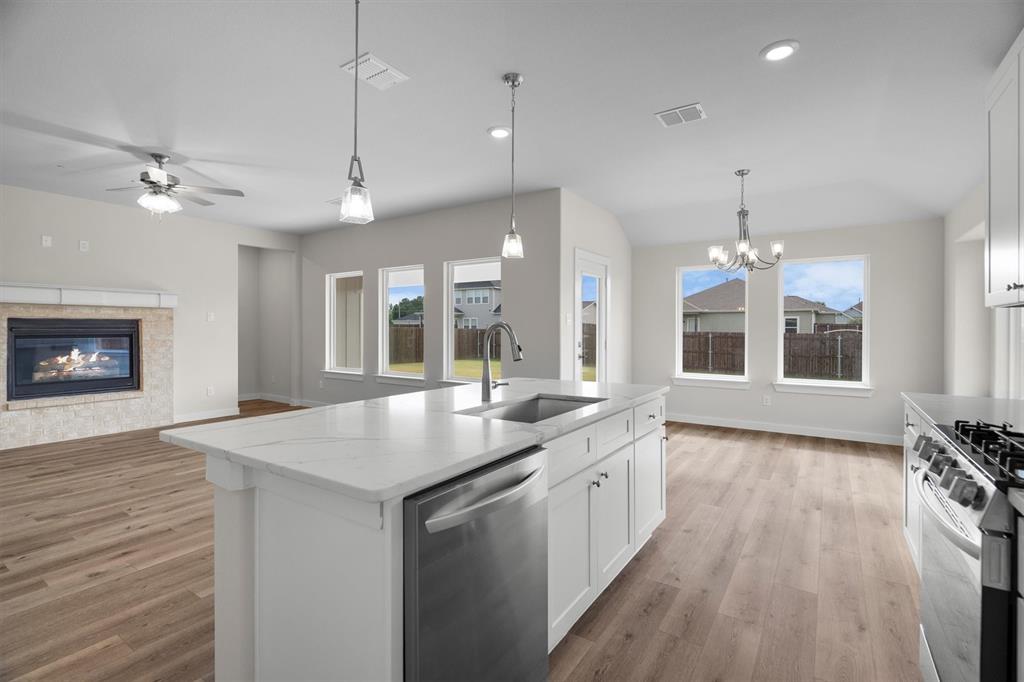 623 Kyle Drive Tioga, TX 76271 - Photo 13 of 40 a open kitchen with stainless steel appliances granite countertop a sink a stove and a wooden floors