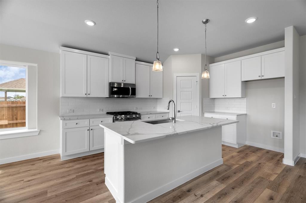 623 Kyle Drive Tioga, TX 76271 - Photo 17 of 40 a kitchen with stainless steel appliances granite countertop a sink a stove a refrigerator and island with wooden floor