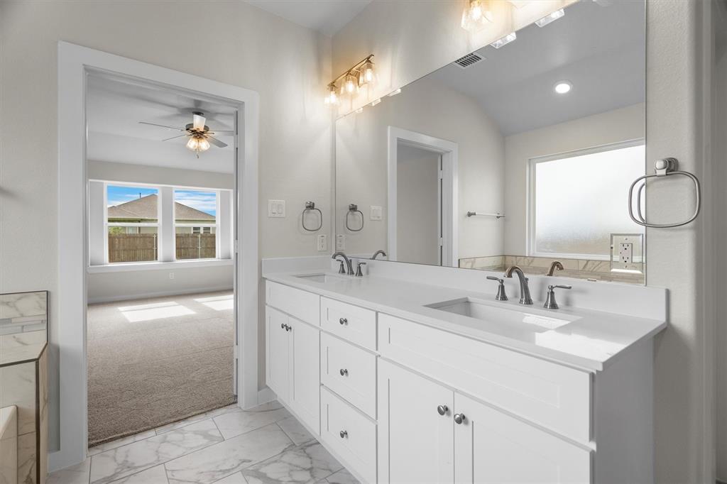 623 Kyle Drive Tioga, TX 76271 - Photo 27 of 40 a bathroom with a double vanity sink and a mirror