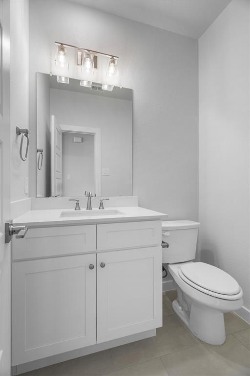 623 Kyle Drive Tioga, TX 76271 - Photo 32 of 40 a bathroom with a toilet a sink and mirror