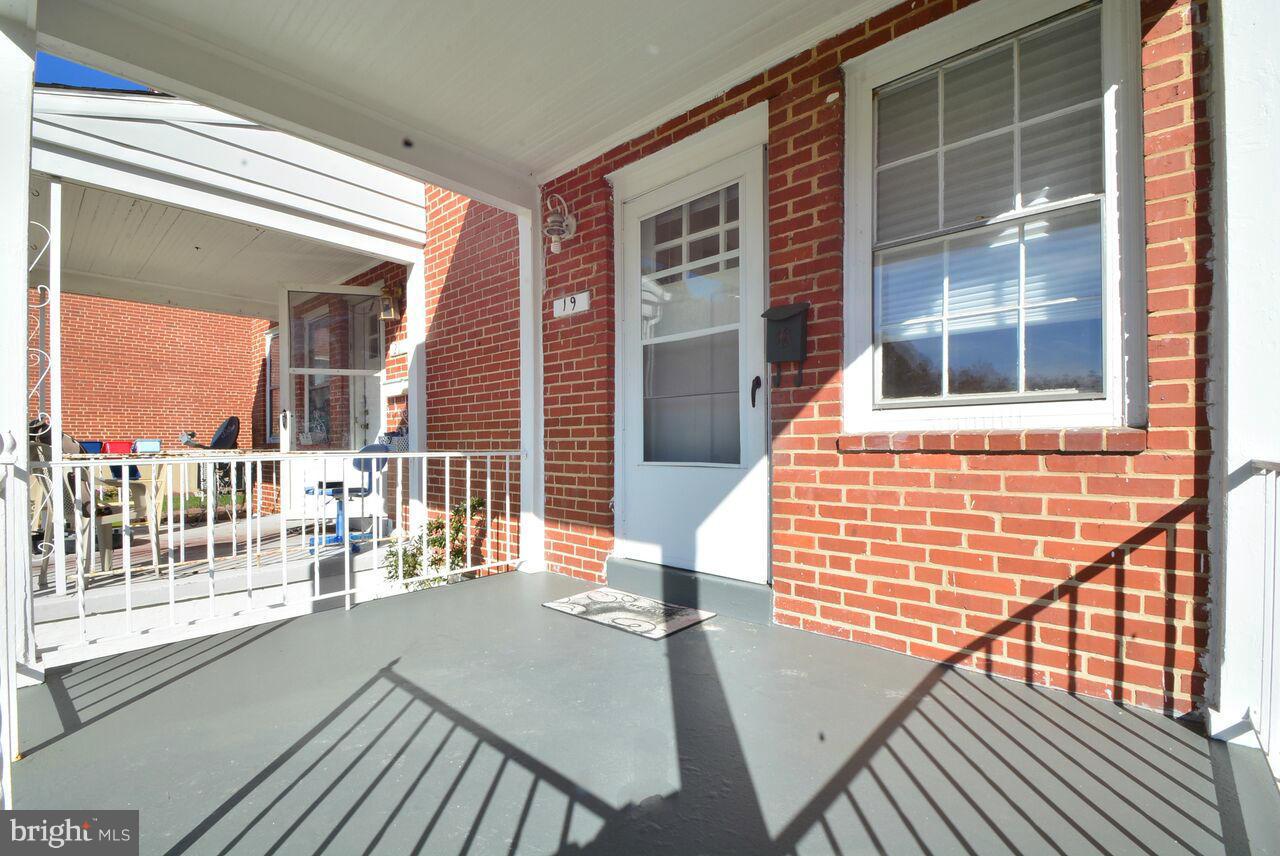 19 Cardinal Road Essex, MD 21221 - Photo 2 of 23 a view of a balcony with a dining table and chairs with wooden floor