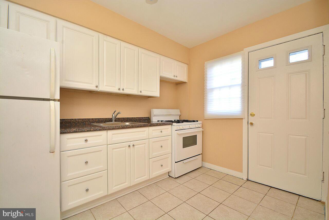 19 Cardinal Road Essex, MD 21221 - Photo 5 of 23 a kitchen with granite countertop white cabinets and white appliances