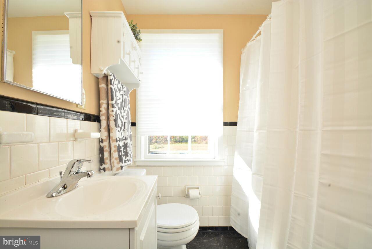 19 Cardinal Road Essex, MD 21221 - Photo 7 of 23 a bathroom with a sink a toilet and a window