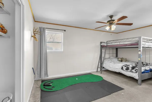 a bedroom with a bed and a chandelier fan