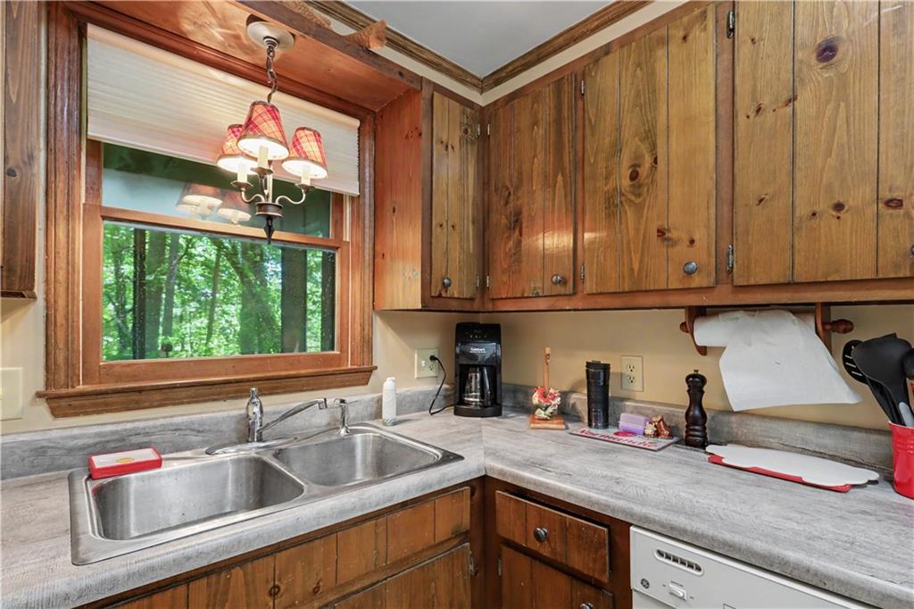 102 Moses Road Rabun Gap, GA 30568 - Photo 14 of 40 a kitchen with stainless steel appliances granite countertop a sink and a wooden cabinets