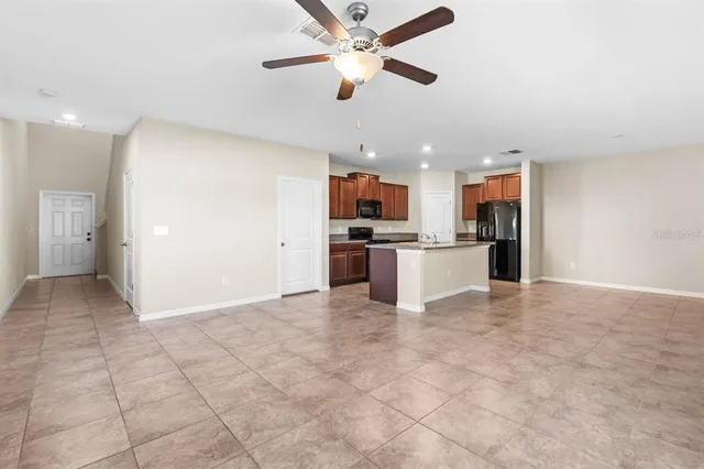 a view of a kitchen with a stove cabinets a ceiling fan and wooden floor