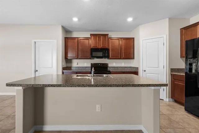 a kitchen with granite countertop a sink and a refrigerator