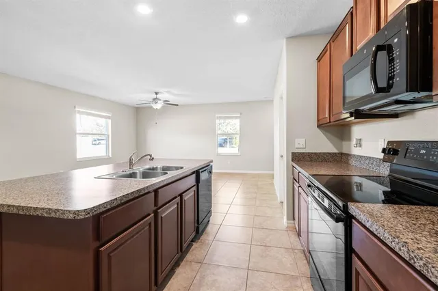 a kitchen with stainless steel appliances granite countertop a sink stove and microwave