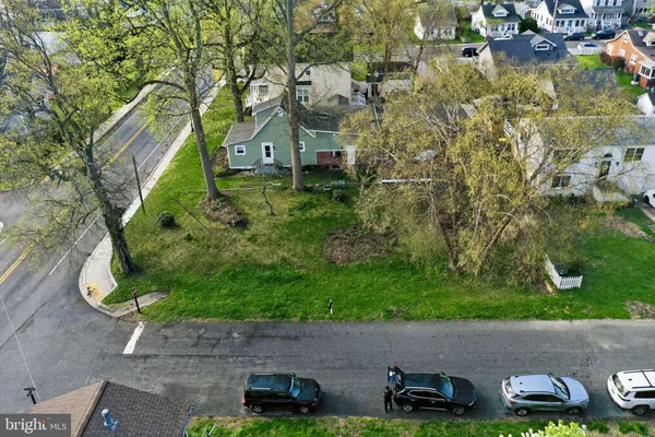 a view of a house with a big yard and large trees