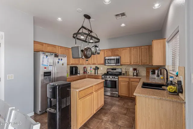 a kitchen with stainless steel appliances granite countertop white cabinets and a stove top oven with granite countertops