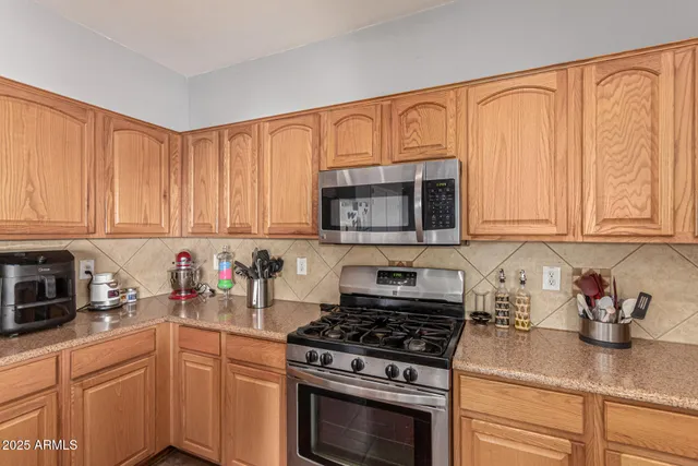 a kitchen with stainless steel appliances granite countertop a sink a stove and a refrigerator