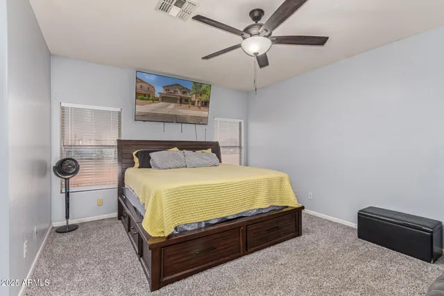 a bed room with a bed and a ceiling fan