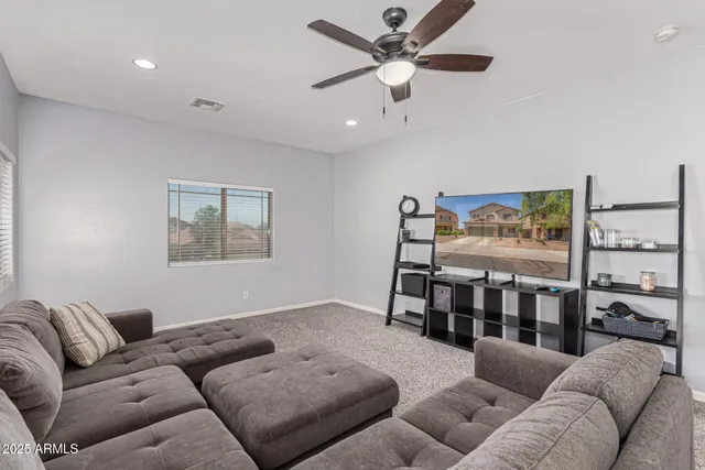 a living room with furniture a ceiling fan and a rug