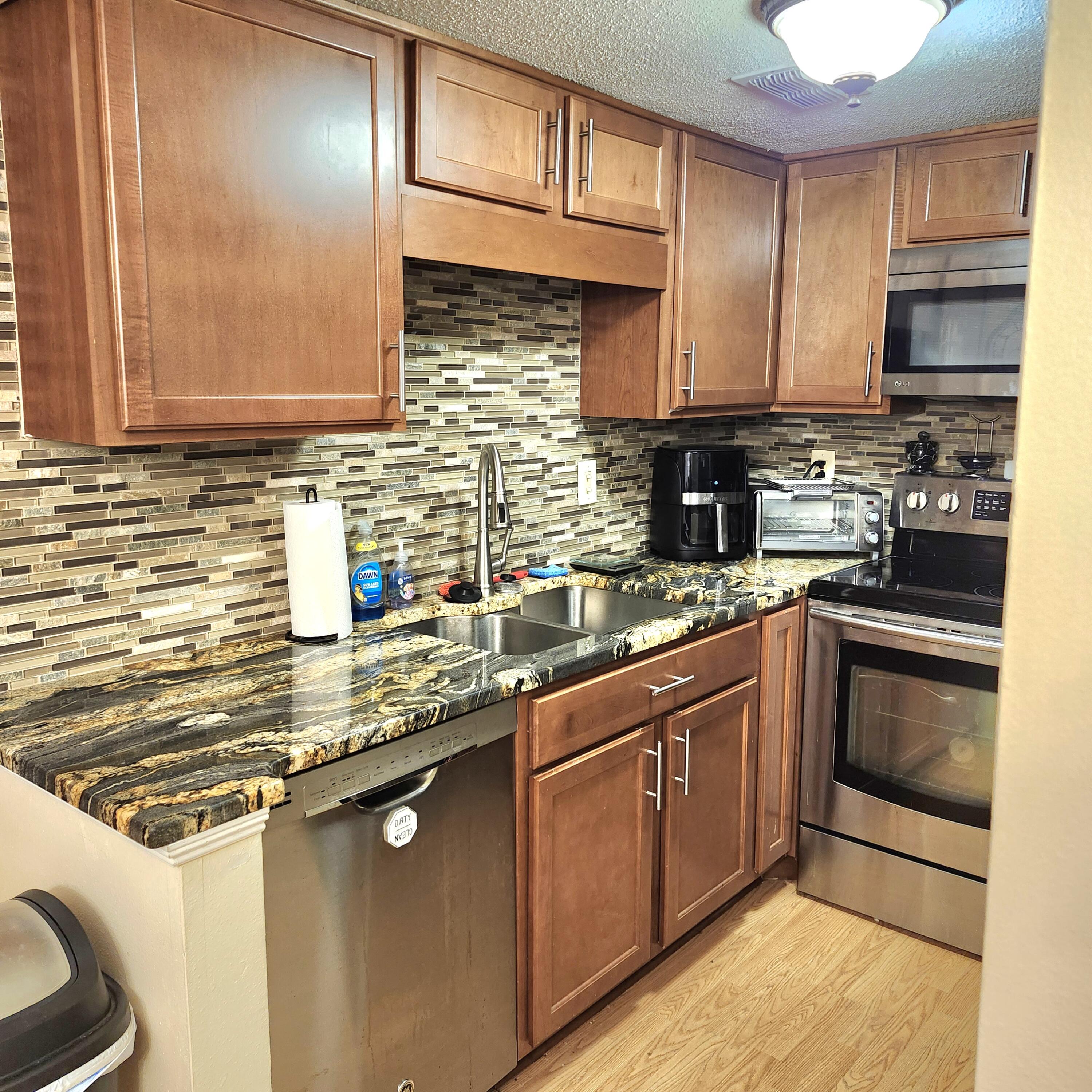 101 Old Ferry Road, Unit 8D Shalimar, FL 32579 - Photo 10 of 21 a kitchen with stainless steel appliances granite countertop a sink stove and cabinets