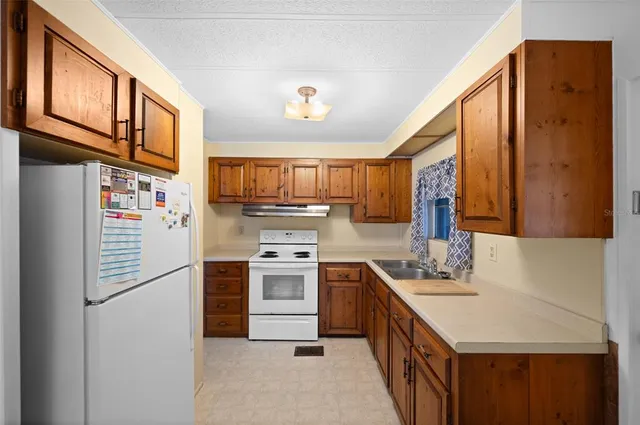 a kitchen with stainless steel appliances granite countertop a refrigerator a stove a sink and a microwave