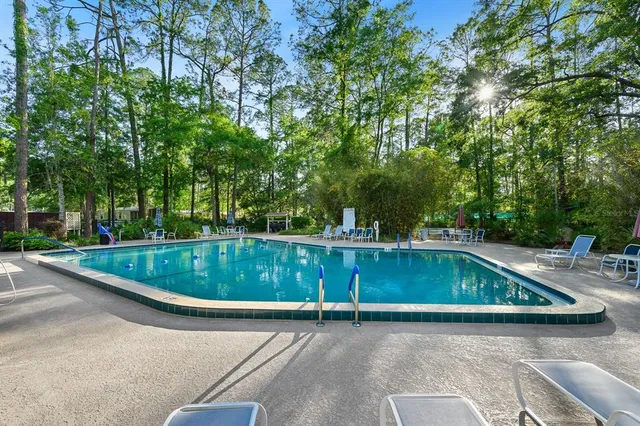 a view of a swimming pool with a patio and a yard
