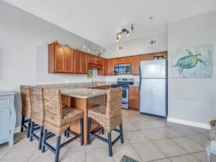 a kitchen with stainless steel appliances granite countertop a refrigerator and a stove top oven