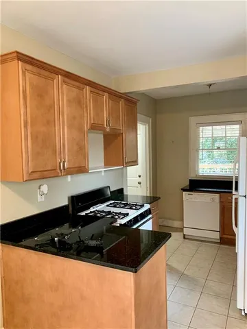 a kitchen with granite countertop a stove a sink and a microwave