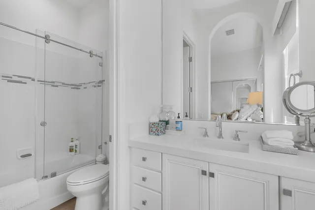 a large bedroom with a large bed and a flat tv screen on a dresser