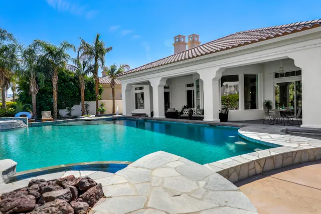 a patio with a table and chairs under an umbrella