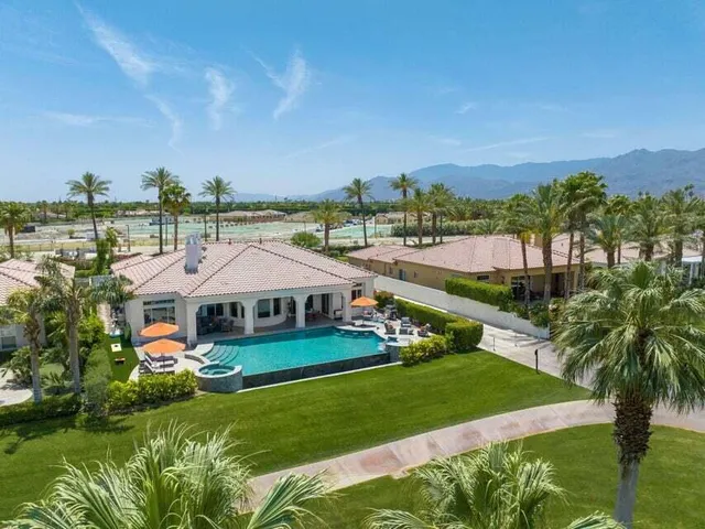 a view of a patio with chairs and table under an umbrella