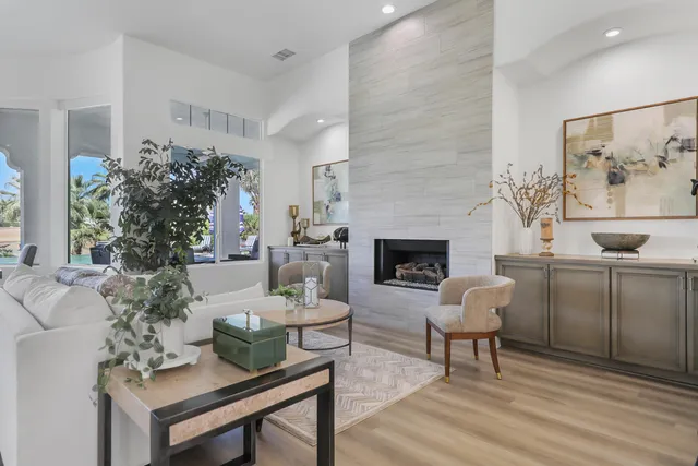 a living room with furniture a fireplace and a potted plant