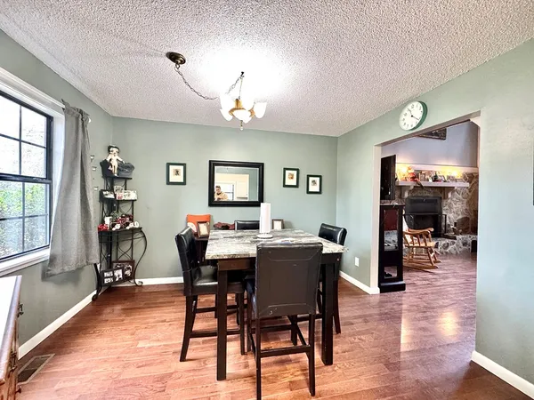 a kitchen with a refrigerator a stove a sink and white cabinets with wooden floor