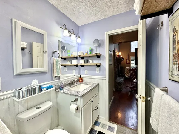 a spacious bedroom with a bed a ceiling fan and a dresser