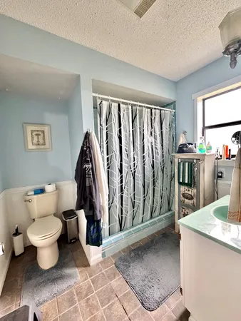 a bathroom with a granite countertop sink a mirror a vanity and a shower
