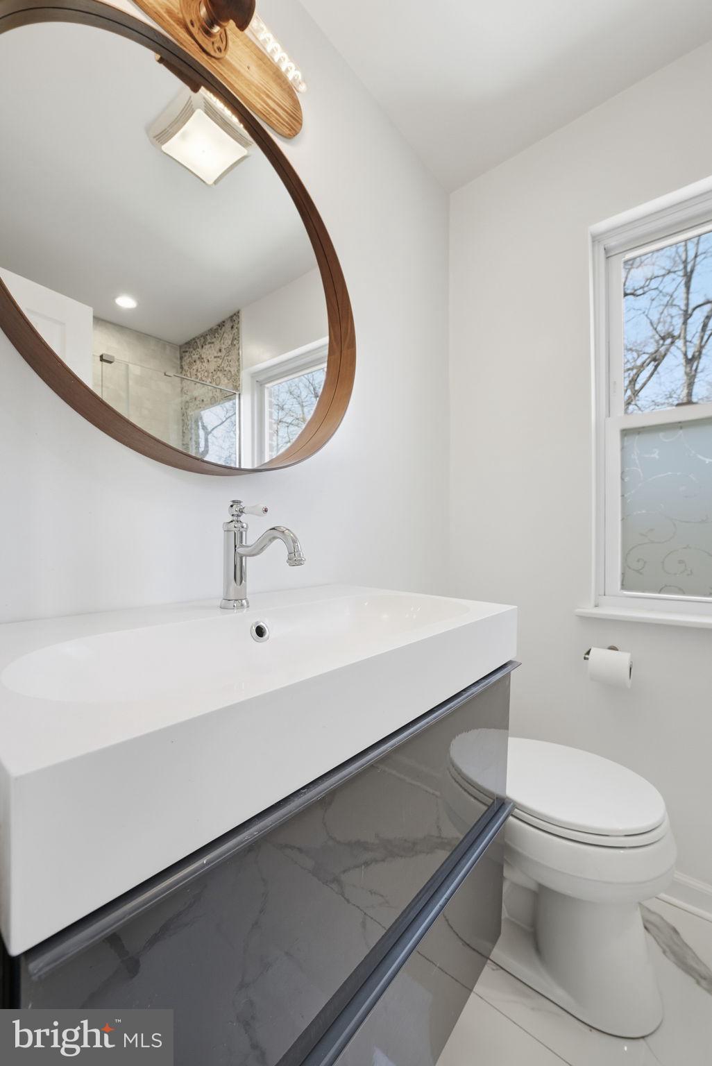 8712 Geren Road Silver Spring, MD 20901 - Photo 32 of 72 a bathroom with a sink a toilet and a mirror