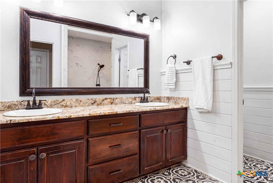 790 Spanish Grant Road Goliad, TX 77963 - Photo 18 of 41 a bathroom with a granite countertop sink and a mirror