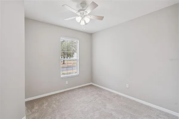 an empty room with a window and a fan