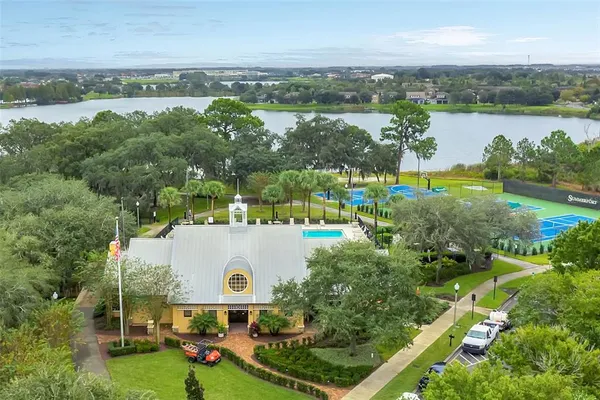 an aerial view of lake and residential houses with outdoor space and trees