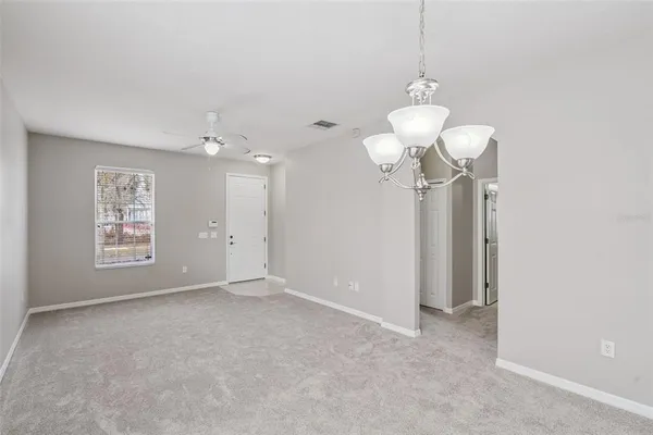 a view of a chandelier in big room and a bathroom