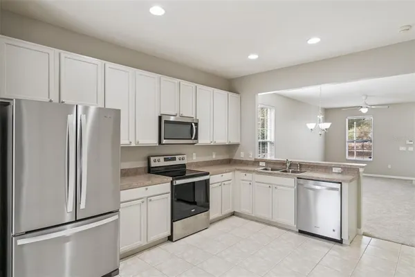 a kitchen with white cabinets and stainless steel appliances