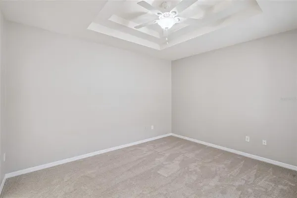 an empty room with a chandelier fan