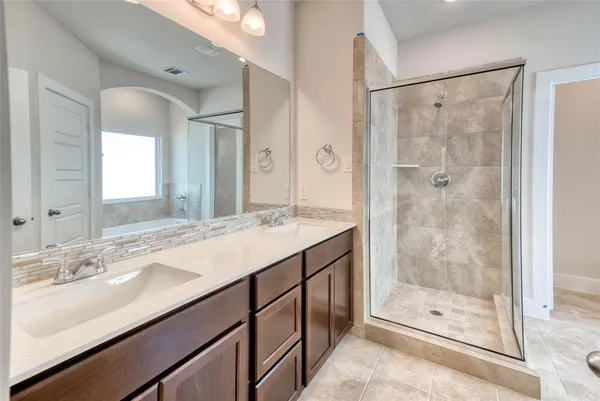 a bathroom with a shower sink and mirror