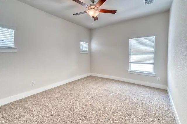 an empty room with a window and a fan