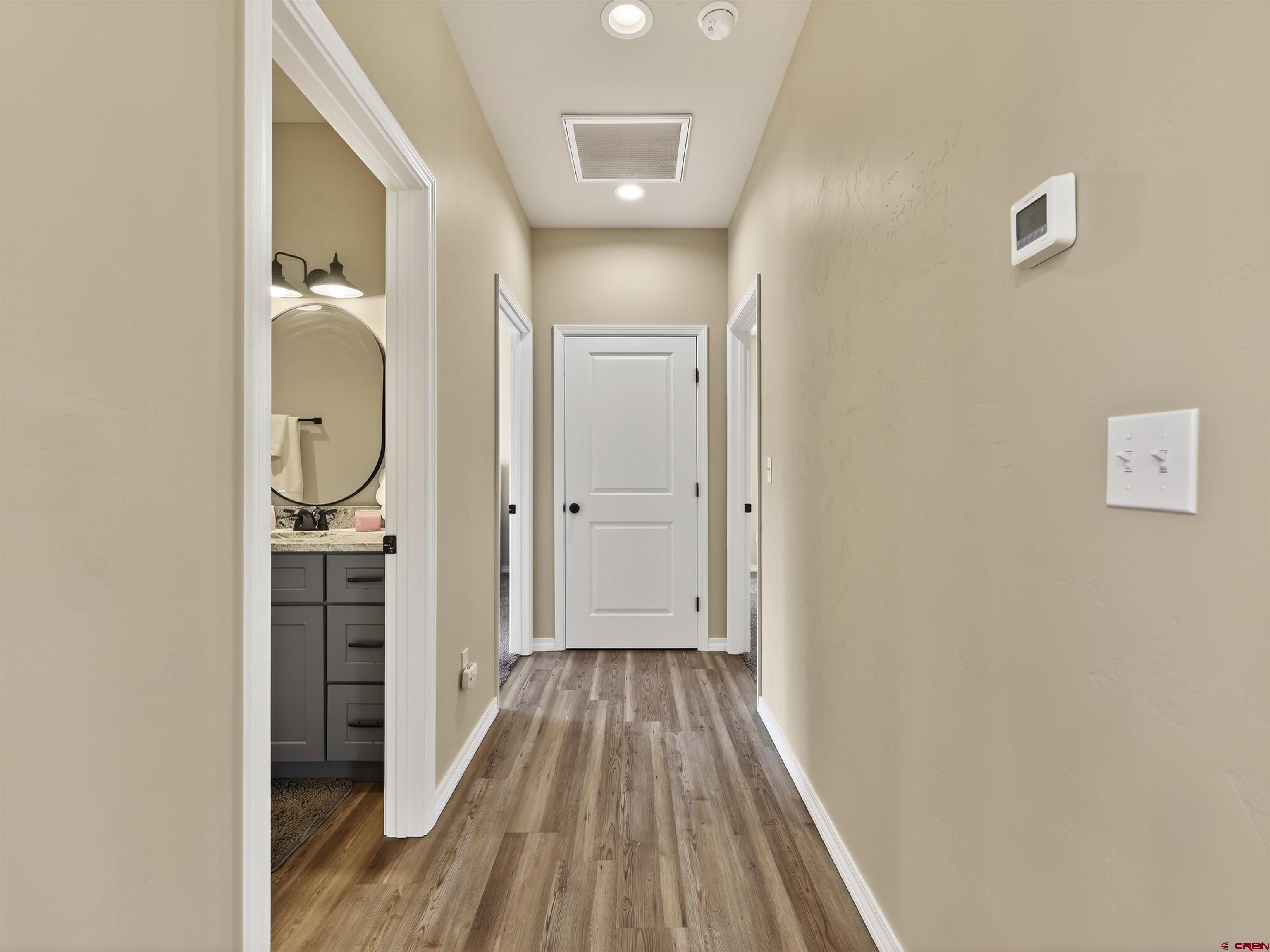 1615 Rivera Street Cortez, CO 81321 - Photo 14 of 21 a view of a hallway with wooden floor and a bathroom