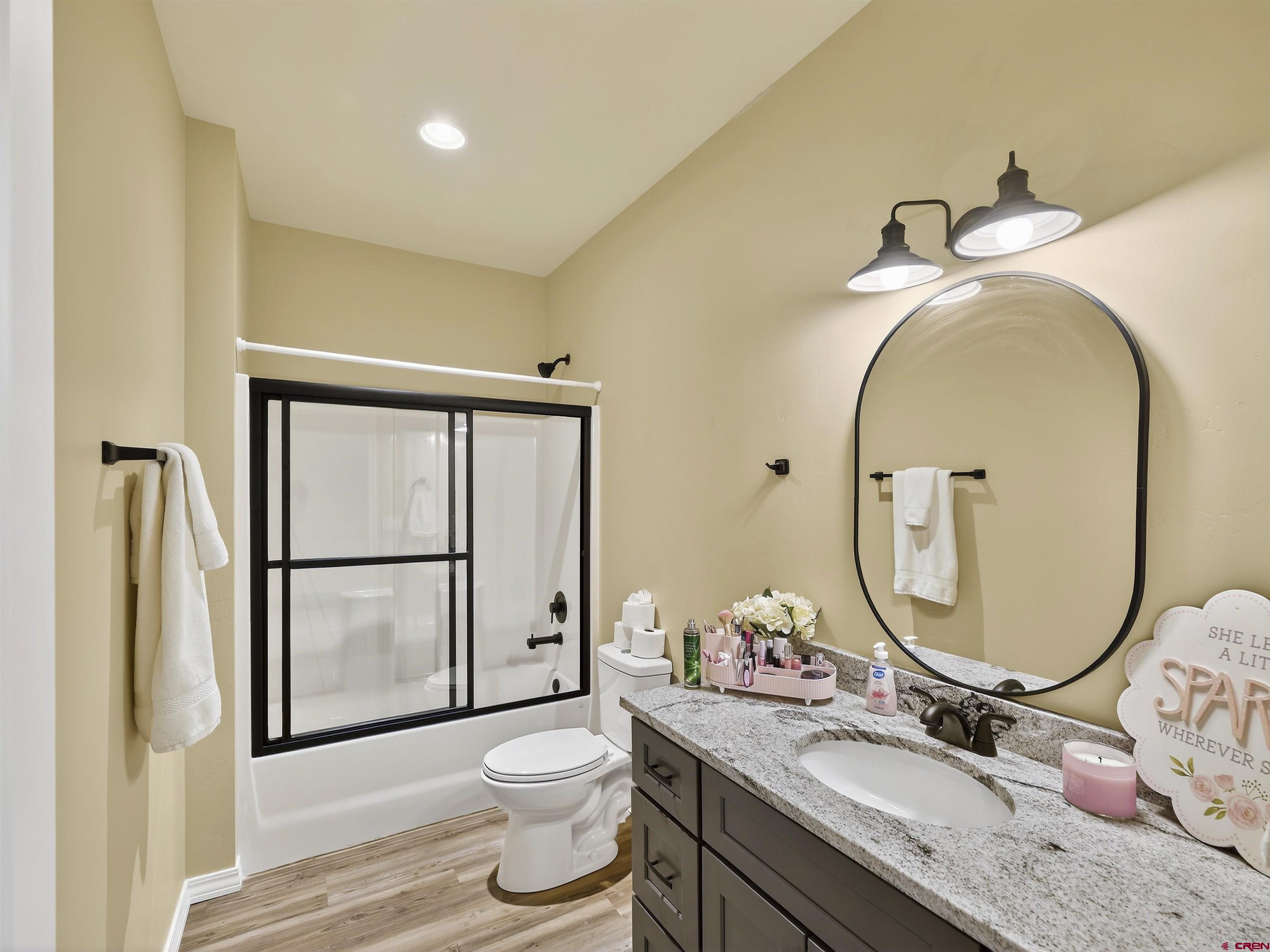 1615 Rivera Street Cortez, CO 81321 - Photo 15 of 21 a bathroom with a granite countertop toilet sink and mirror