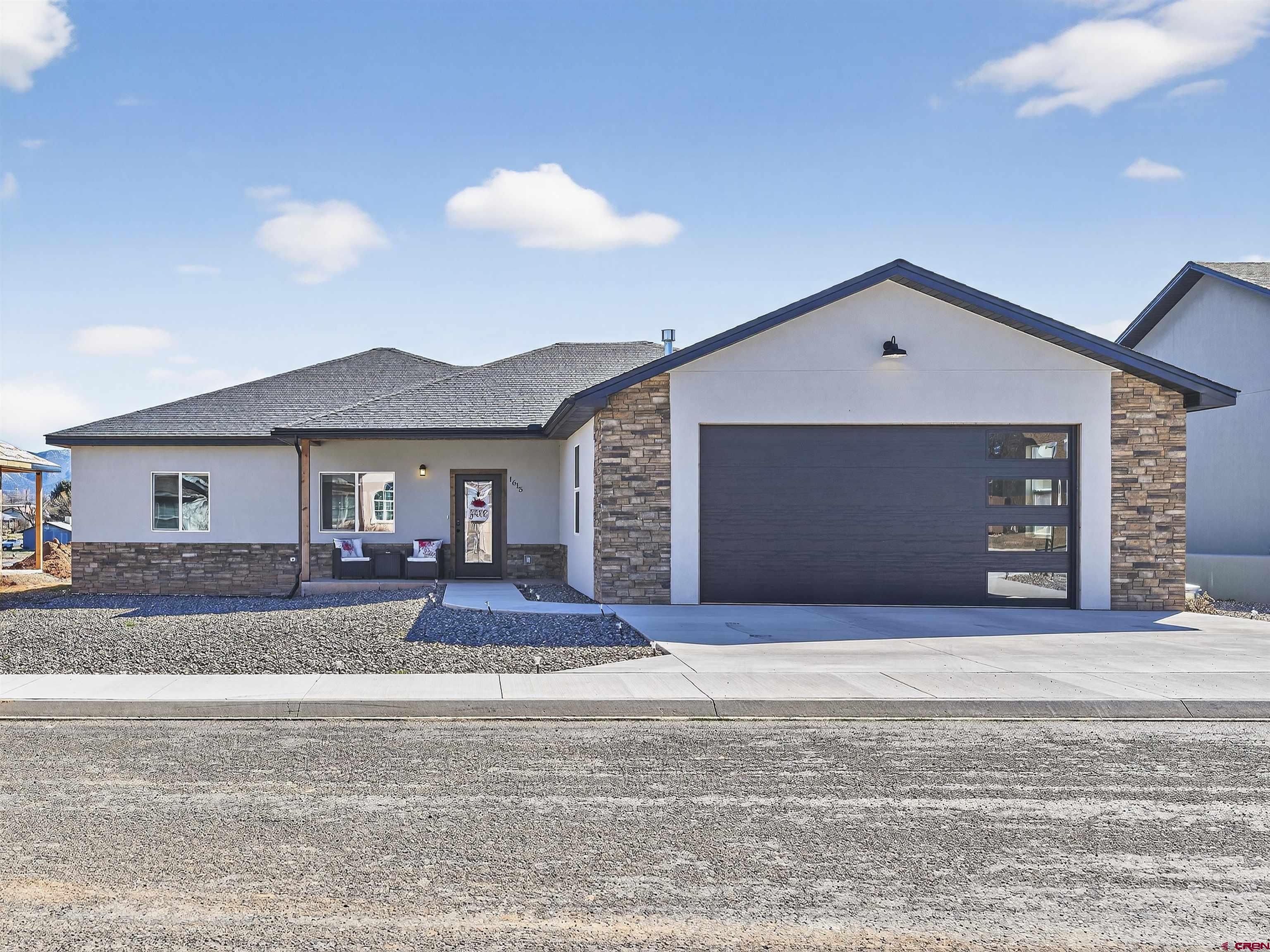 1615 Rivera Street Cortez, CO 81321 - Photo 21 of 21 a front view of a house with a yard and garage