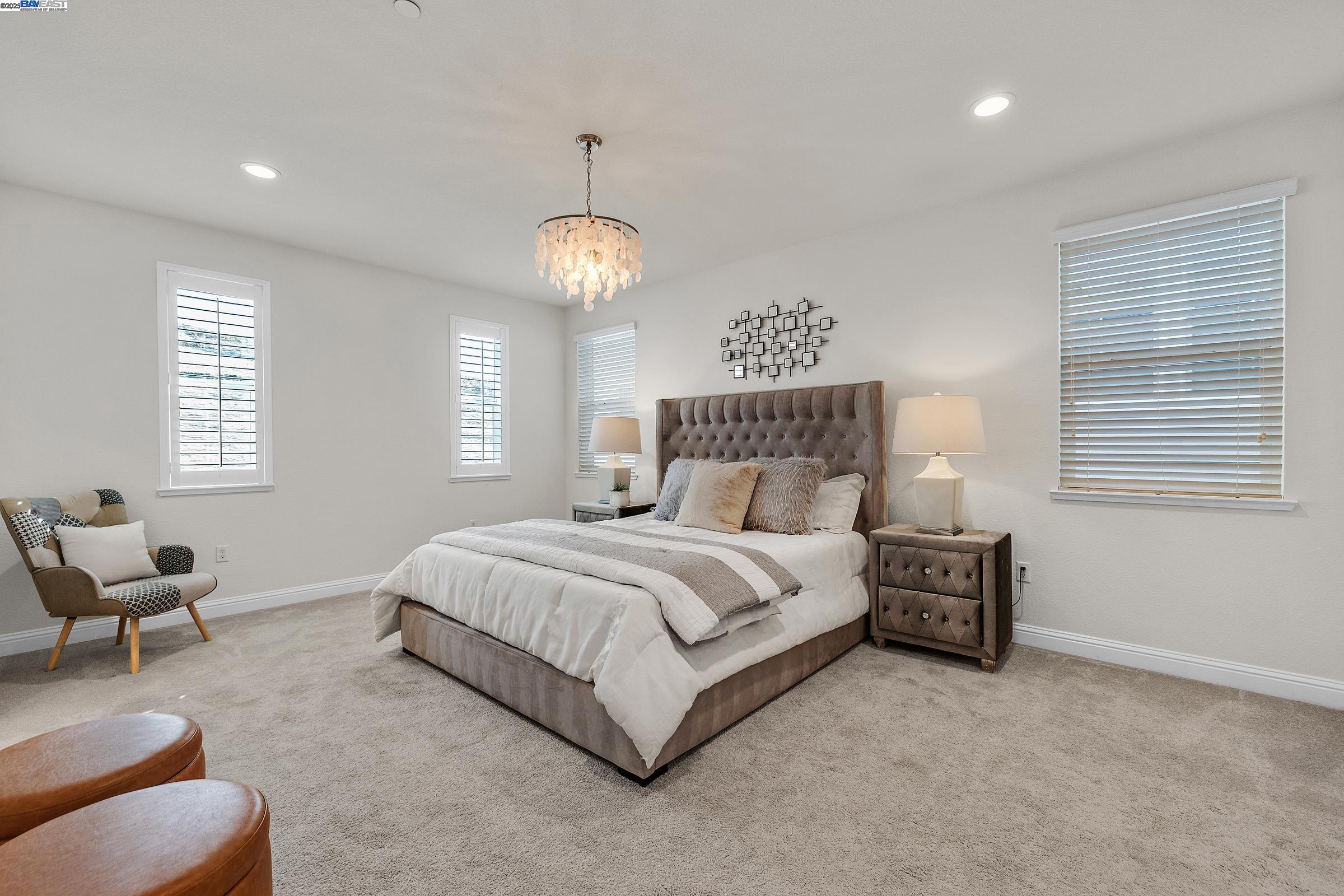 4519 Spring Mountain Way Dublin, CA 94568 - Photo 31 of 52 a spacious bedroom with a bed and a chandelier