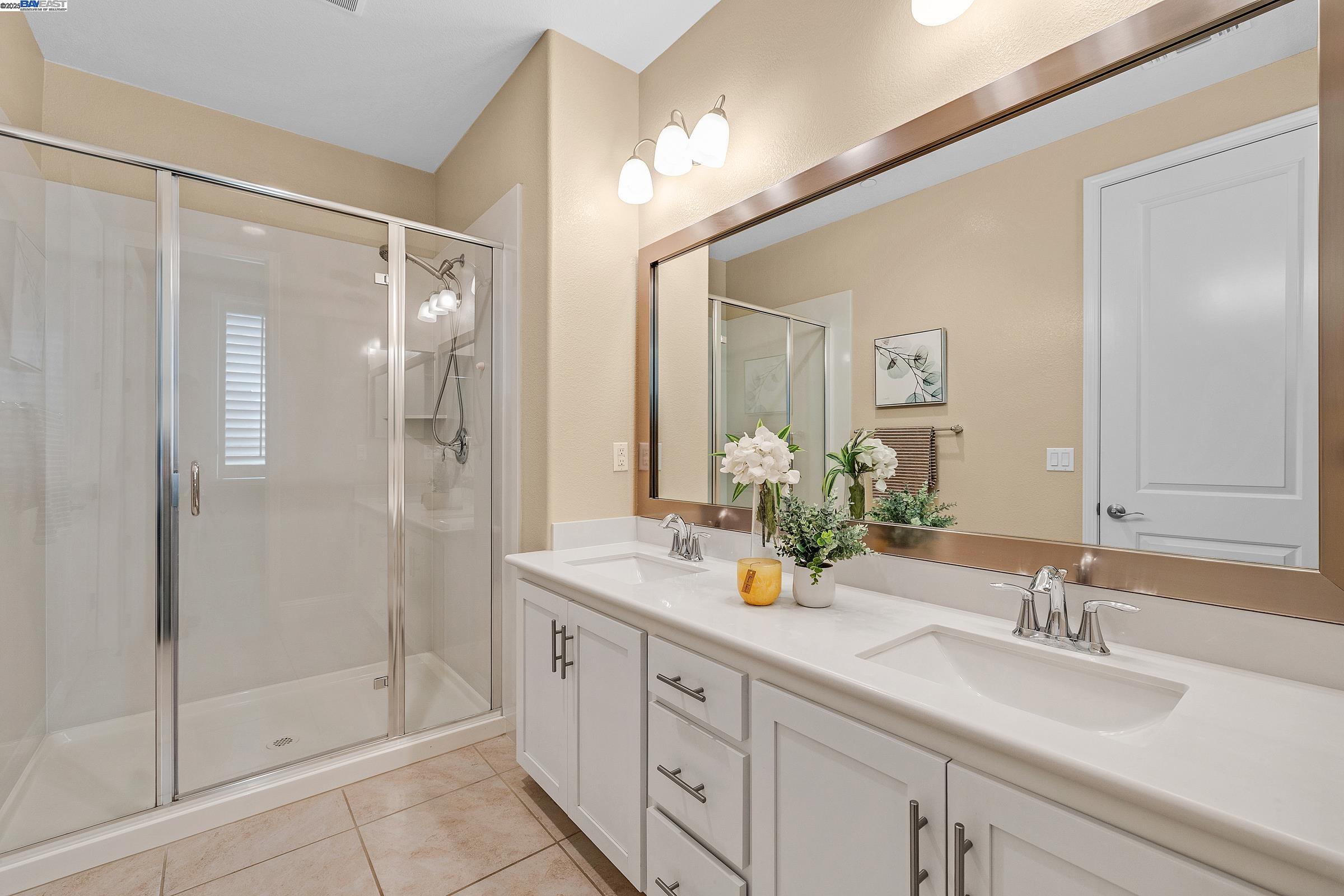 4519 Spring Mountain Way Dublin, CA 94568 - Photo 33 of 52 a bathroom with a shower sink and mirror